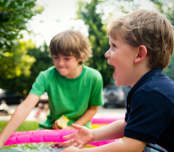 boy in blue shirt screaming near boy in green crew-neck shirt